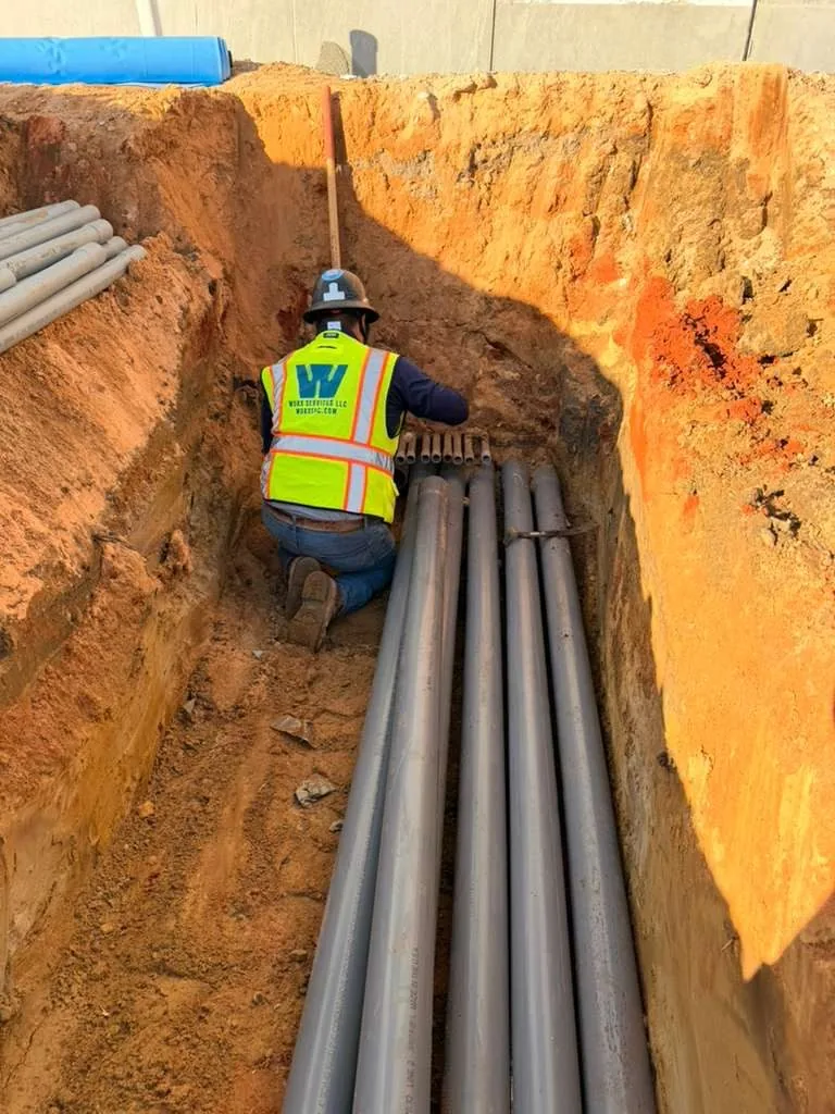WORX Services worker installing underground conduit in a trench